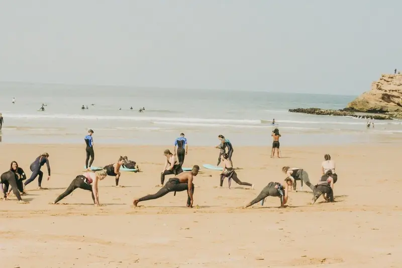 Group stretching on the beach, surf, stay and yoga package, 5 nights
