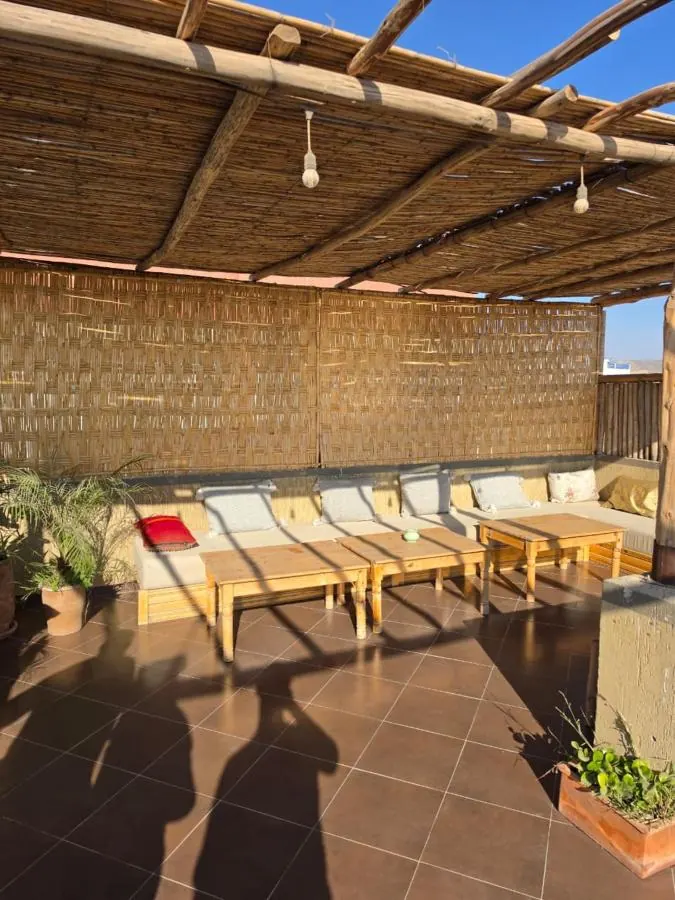 Rooftop terrace with lounge seating and reed shade at NAVA in Tamraght