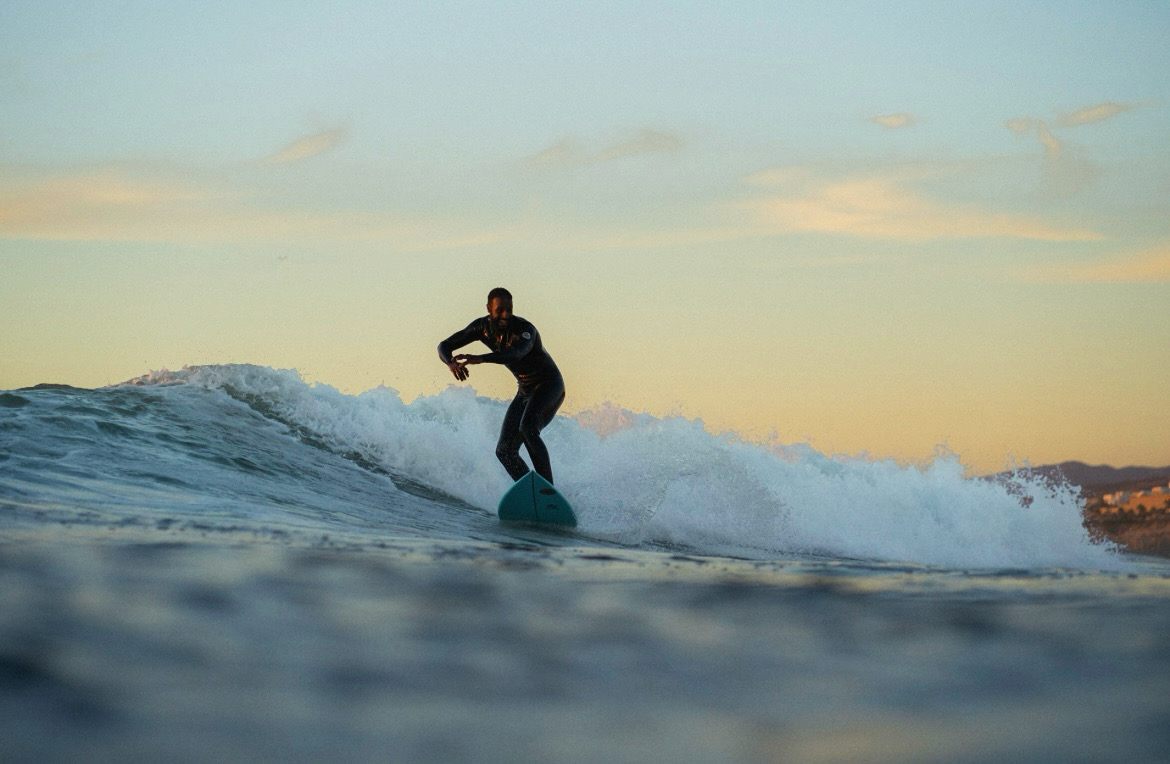 Surfer silhouetted against a Moroccan sunset